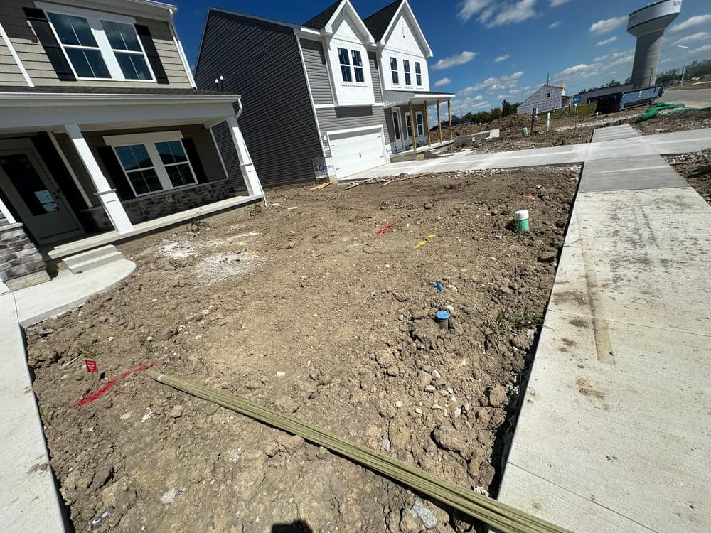 Construction site with new homes, marked pathways, and clear blue sky.